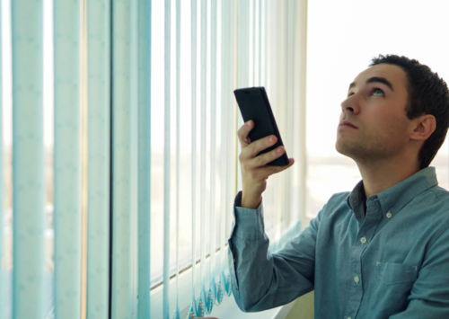Man using button to control motorized blinds in Scottsdale AZ and Boerne TX