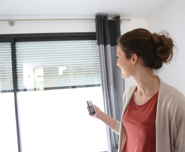 Woman using motorized drapes in Scottsdale AZ - Blinds by Design SW