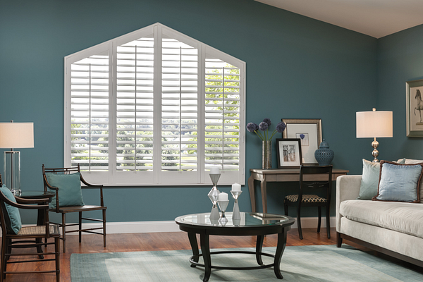Angled white shutters against a blue wall